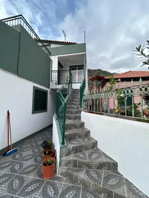 a staircase leading up to a house with potted plants at Celina Residence in Ribeira Brava