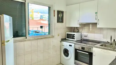 a kitchen with a washing machine and a microwave at Green Haven in Funchal