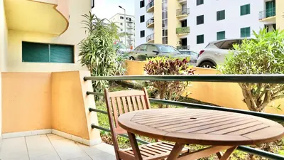 a wooden table and a chair on a balcony at Green Haven in Funchal