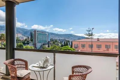 a balcony with chairs and a table with a view at Suite 106 in Funchal