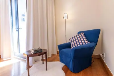 a living room with a blue chair and a table at Suite 106 in Funchal