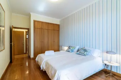 a bedroom with a white bed and a wooden floor at Suite 106 in Funchal