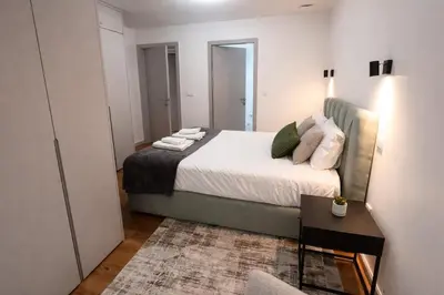 a bedroom with a bed and a table and a mirror at Oudinot Residence by Mercado dos Lavradores com AC in Funchal