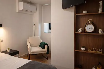 a bedroom with a bed and a chair and a clock at Oudinot Residence by Mercado dos Lavradores com AC in Funchal