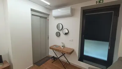 a room with a table and a mirror on a wall at Oudinot Residence by Mercado dos Lavradores com AC in Funchal