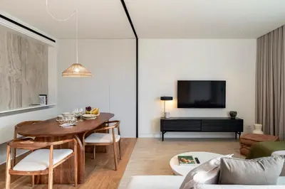 a living room with a table and a tv at Savoy Monumentalis I by An Island Apart in Funchal