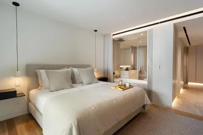 a bedroom with a large white bed and a bathroom at Savoy Monumentalis I by An Island Apart in Funchal