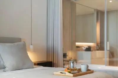 a bedroom with a bed with a tray of food and a bath tub at Savoy Monumentalis I by An Island Apart in Funchal