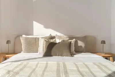 a bed with white sheets and pillows on it at Acqua Residence II by An Island Apart in Funchal