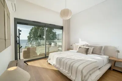 a white bedroom with a bed and a large window at Acqua Residence II by An Island Apart in Funchal