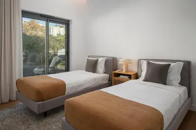 two beds in a room with a window at Acqua Residence II by An Island Apart in Funchal