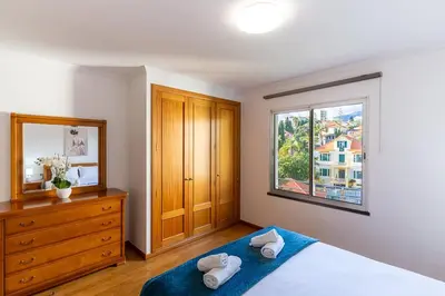 a bedroom with a bed and a dresser and a window at GuestReady - Charming retreat in Funchal in Funchal