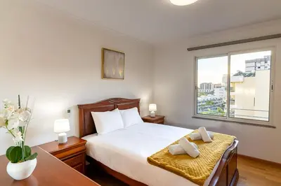 a bedroom with a bed and a large window at GuestReady - Charming retreat in Funchal in Funchal