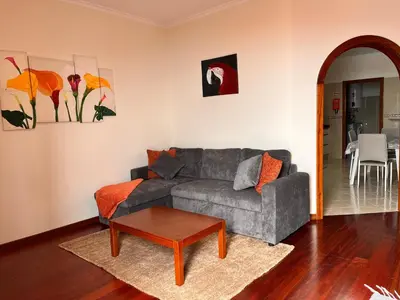 an orange and white building with chairs and tables at Apartamento Pestana in Arco da Calheta