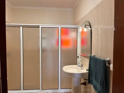 a bathroom with a shower and a sink and a mirror at Apartamento Pestana in Arco da Calheta