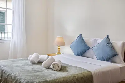 a white bed with blue pillows and towels on it at Horizon Glow II by Zest & Guest in Ponta do Pargo