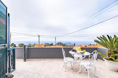 a patio with a table and chairs on a balcony at Horizon Glow II by Zest & Guest in Ponta do Pargo