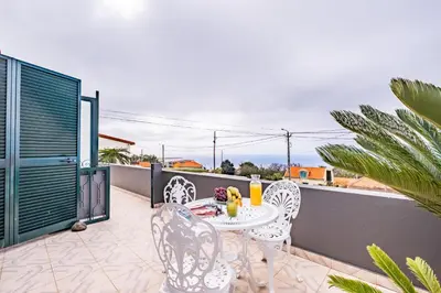 a patio with a table and chairs on a balcony at Horizon Glow II by Zest & Guest in Ponta do Pargo