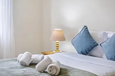 a bedroom with a bed with towels and a lamp at Horizon Glow II by Zest & Guest in Ponta do Pargo