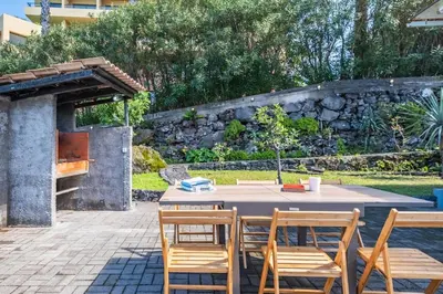 a patio with a table and chairs and a fireplace at SUPER Sunset in Ponta Delgada