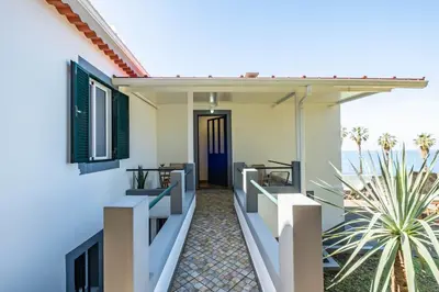 a house with a balcony with a view of the ocean at SUPER Sunset in Ponta Delgada