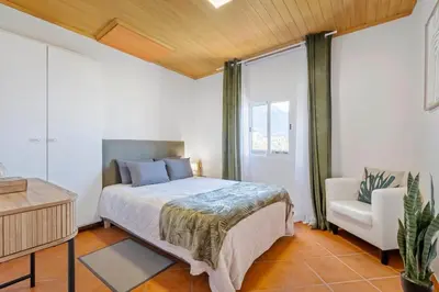 a bedroom with a bed and a chair at SUPER Sunset in Ponta Delgada