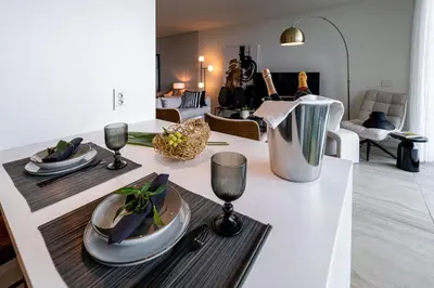 a kitchen with a table with plates and wine glasses at Savoy Residence Monumentalis VA by LM&AC Signature in Funchal