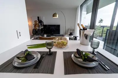 a kitchen counter with a table with plates and wine glasses at Savoy Residence Monumentalis VA by LM&AC Signature in Funchal