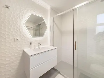 a white bathroom with a sink and a mirror at BoLina Ocean View in Caniço