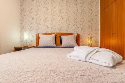 a bedroom with a bed with white blankets and pillows at BoLina Ocean View in Caniço
