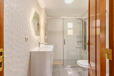 a white bathroom with a sink and a shower at BoLina Ocean View in Caniço