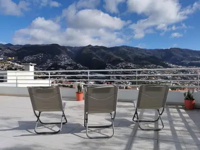 two chairs on a roof with a view of mountains at Pico Barcelos - Funchal in Funchal