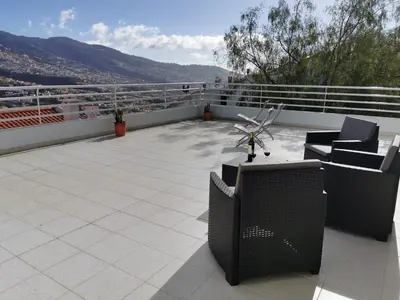 a patio with chairs and tables on a balcony at Pico Barcelos - Funchal in Funchal