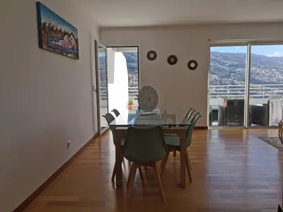 a dining room with a table and chairs with a view at Pico Barcelos - Funchal in Funchal