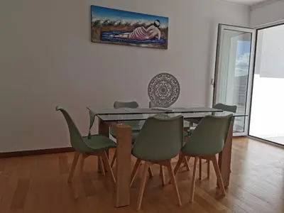a dining room with a glass table and green chairs at Pico Barcelos - Funchal in Funchal