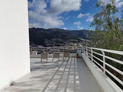 a balcony with chairs and a view of the mountains at Pico Barcelos - Funchal in Funchal