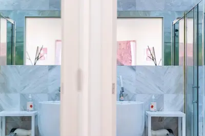 a bathroom with two sinks and two mirrors at GuestReady - Perfect home in the city centre in Funchal