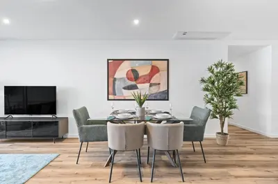 a dining room with a table and chairs and a tv at Oceanfront Elegance Madeira Retreat in Câmara de Lobos