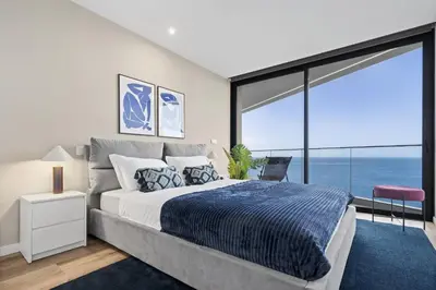 a bedroom with a large bed and a large window at Oceanfront Elegance Madeira Retreat in Câmara de Lobos