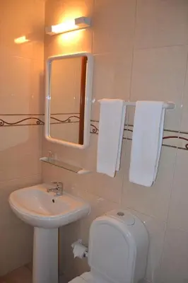 a bathroom with a sink and a toilet and a mirror at Costamar in Lagos