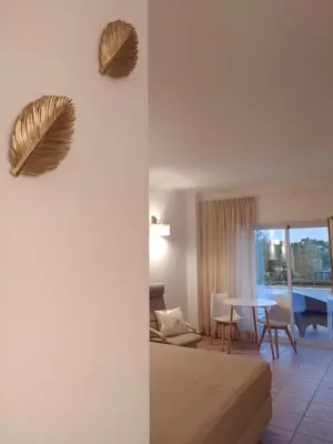 a room with a bed and a living room with a table at Costamar in Lagos