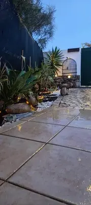 a garden with plants and a fence and a sidewalk at Costamar in Lagos