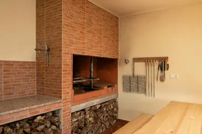 a kitchen with a brick fireplace with a stove at Casa Pimenta in Fajã da Ovelha in Prazeres