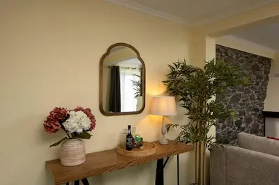 a room with a mirror and a table with flowers at Casa Pimenta in Fajã da Ovelha in Prazeres
