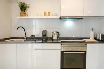 a kitchen with white cabinets and a sink at Madeira Funchal Stay in Funchal
