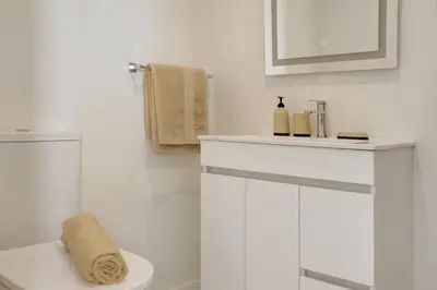 a white bathroom with a toilet and a sink at Madeira Funchal Stay in Funchal