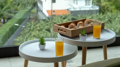 two tables with two glasses of orange juice and a box of pastries at Brava Suite by LovelyStay in Ribeira Brava