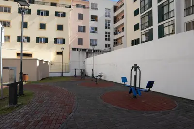 a group of benches in a courtyard with buildings at Brava Suite by LovelyStay in Ribeira Brava
