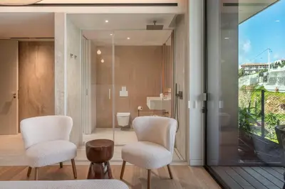 a room with two chairs and a bathroom with a toilet at Savoy Monumentalis III by An Island Apart in Funchal