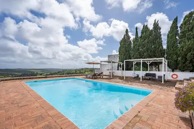 a large swimming pool in a yard with trees at Alto da Lua - Aljezur in Bordeira